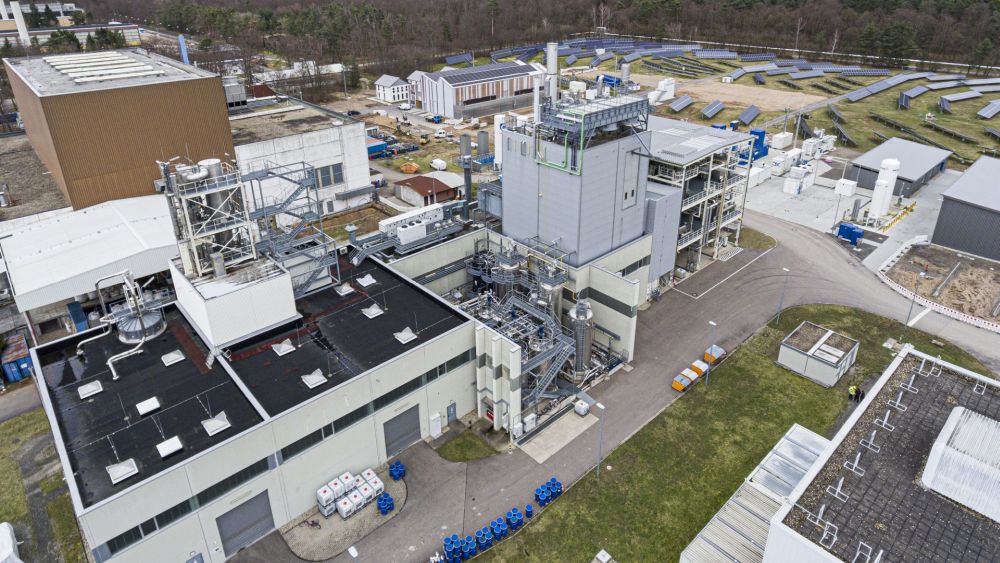 M. Breig, J. Zilius / KIT Aerial view of an industrial complex with surrounding solar panels.